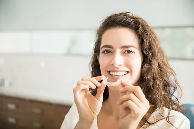 Woman holding clear aligners